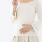 お腹を押さえる女性